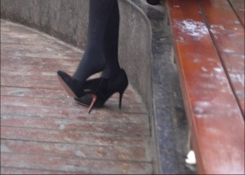 Lonely women has dropped shoes on dangling legs